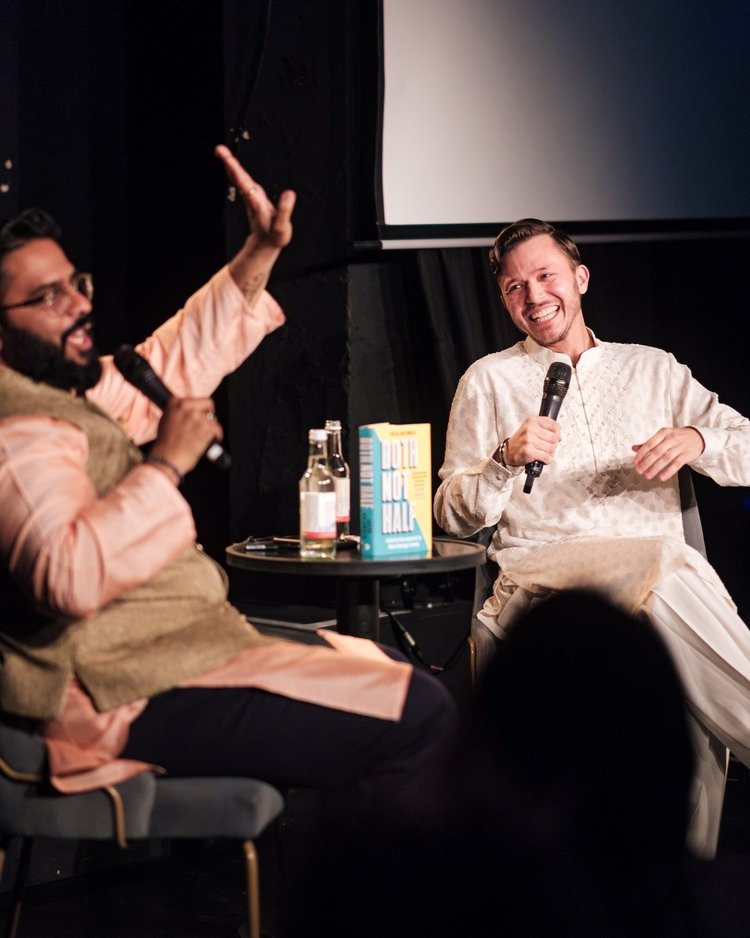 Jassa on stage in conversation, holding a microphone