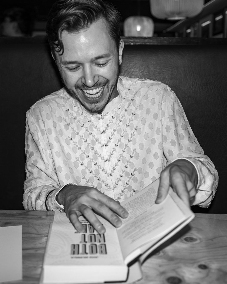 Jassa laughing as he signs a copy of Both Not Half